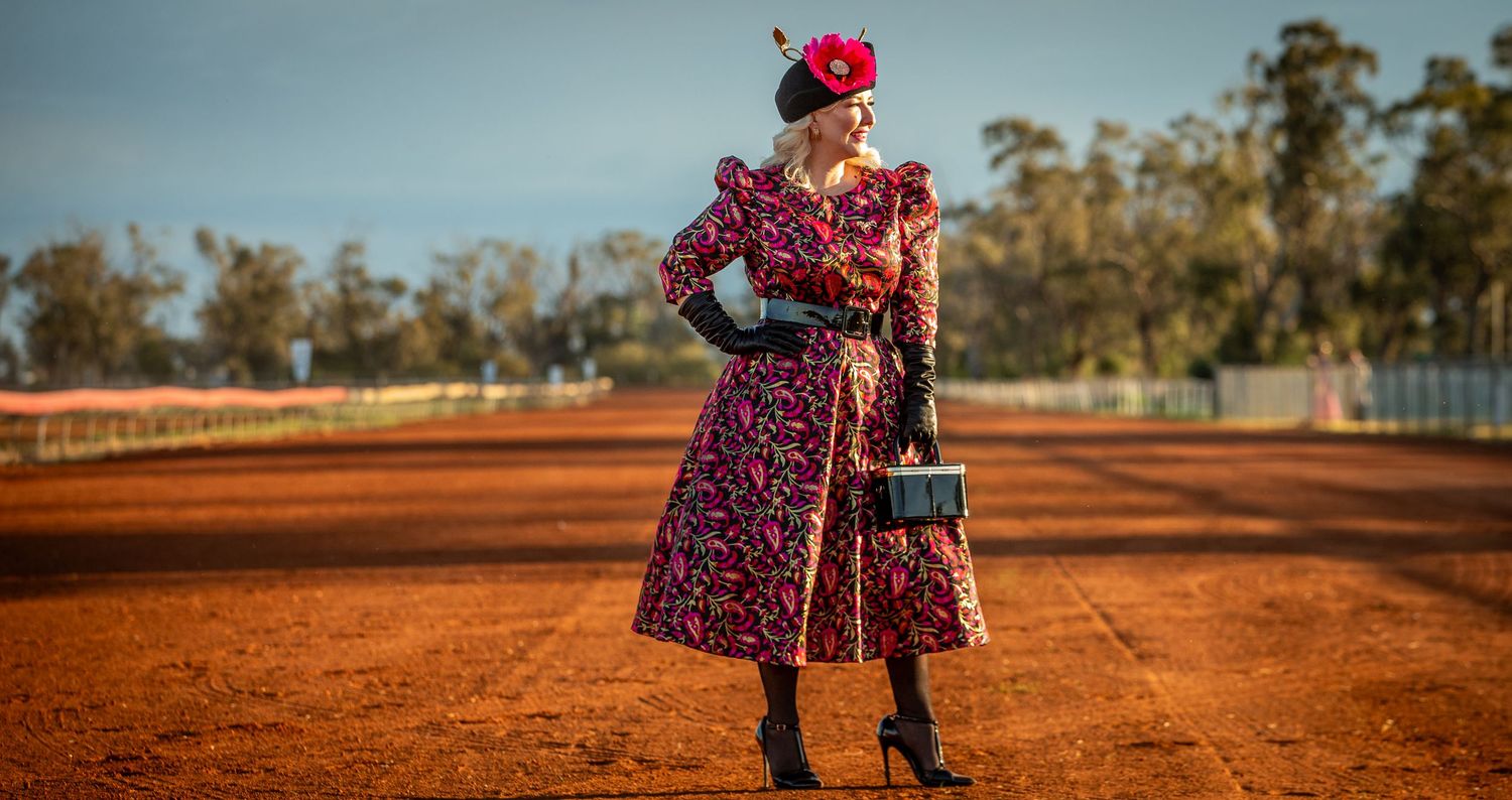 Fashion on a red dirt track at sunset with long shadows and a storm coming behind them.