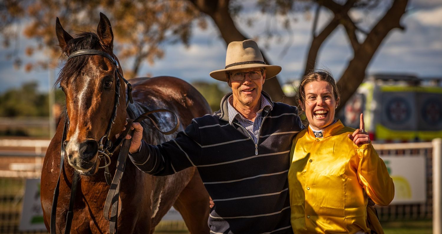 Photo of happy owner and jockey with their winning horse.