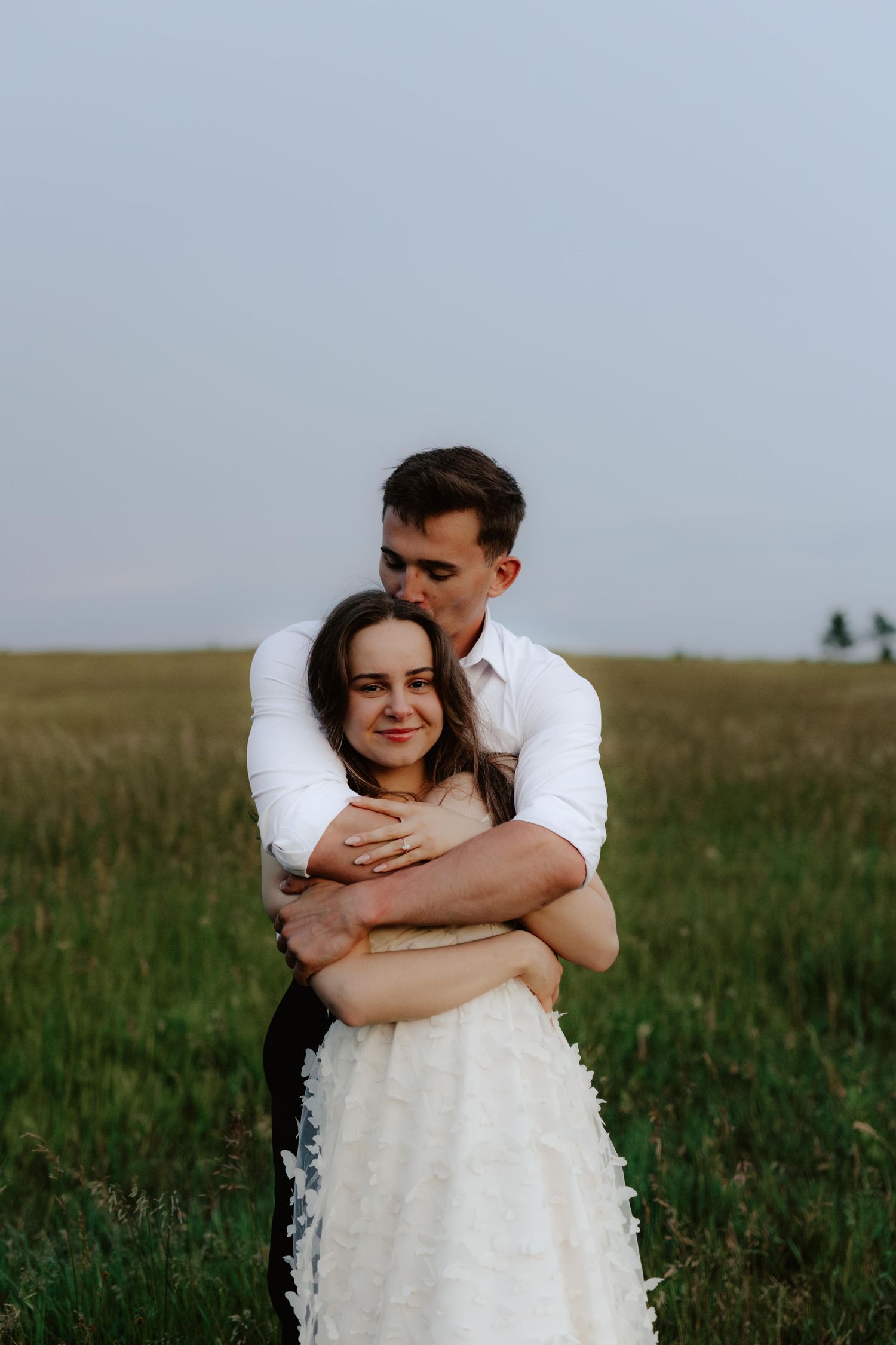 Beautiful couple sharing a romantic blue hour moment during a proposal near a serene pond at summertime in Nebraska