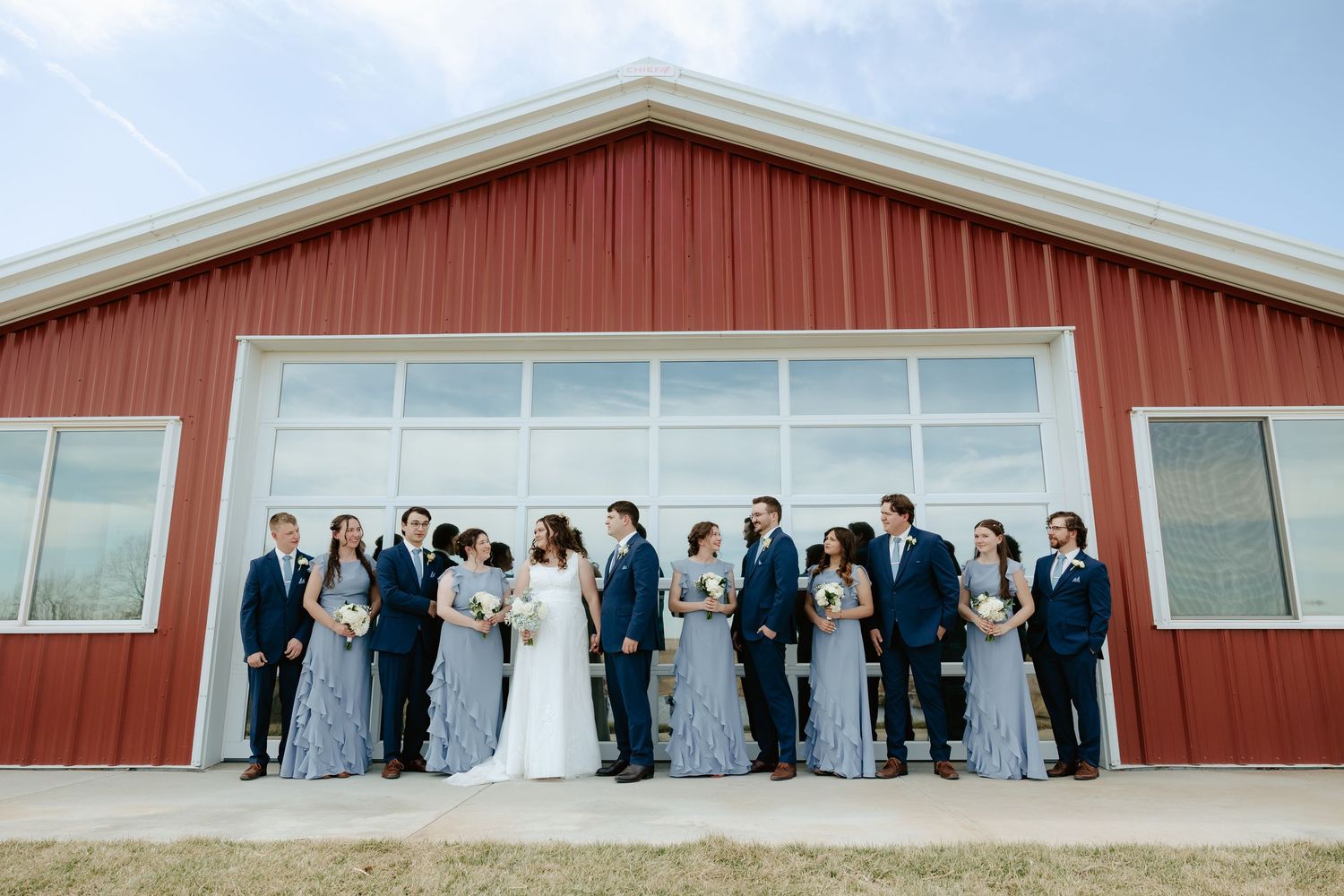 Wedding party poses outside Sparks Barn glass door.