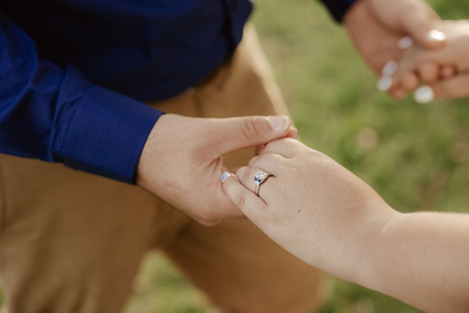 Engaged couple holding hands.
