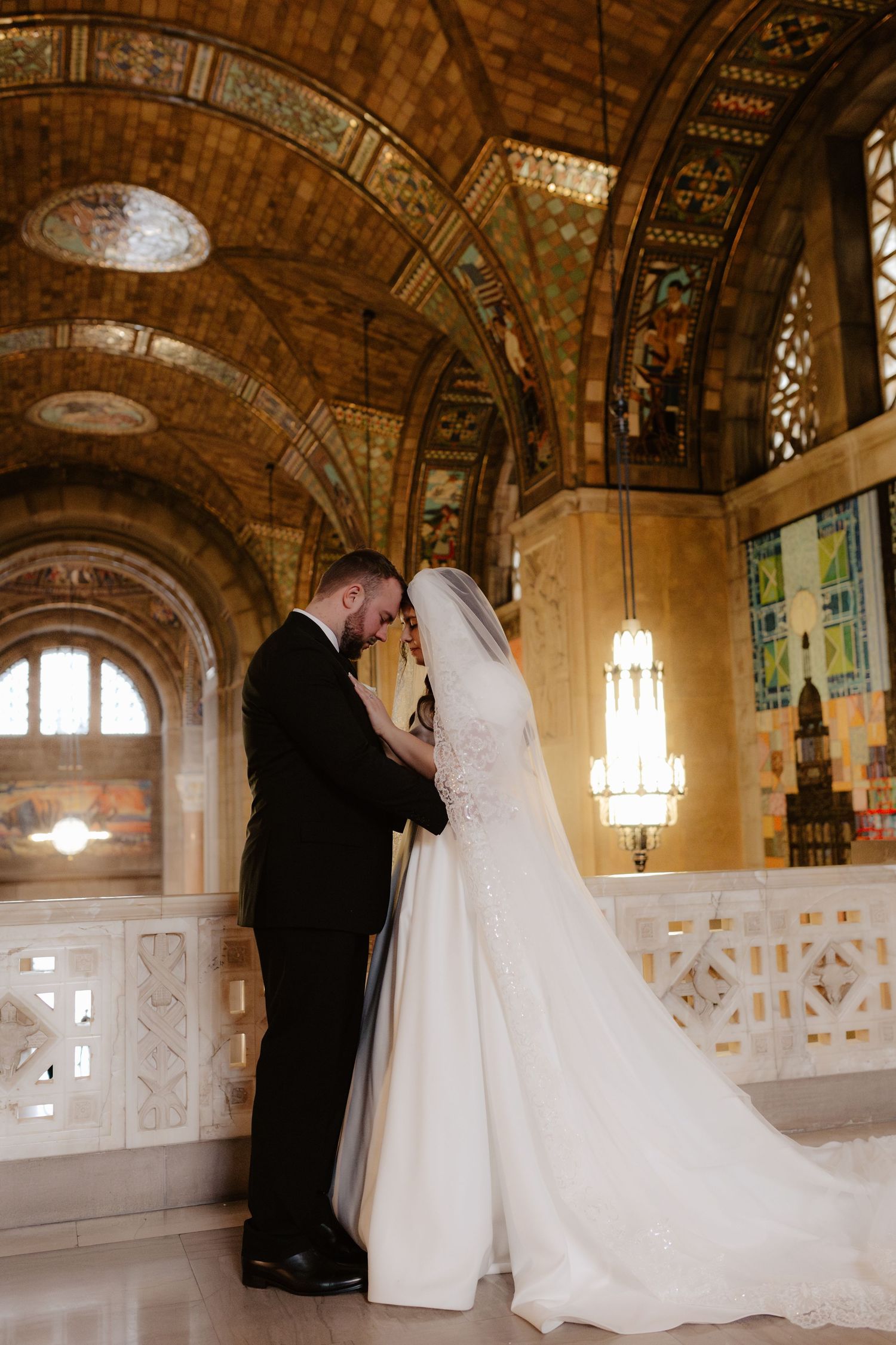 Elegant wedding couple shares intimate moments in the Nebraska State Capitol building rotunda with ornate architecture.