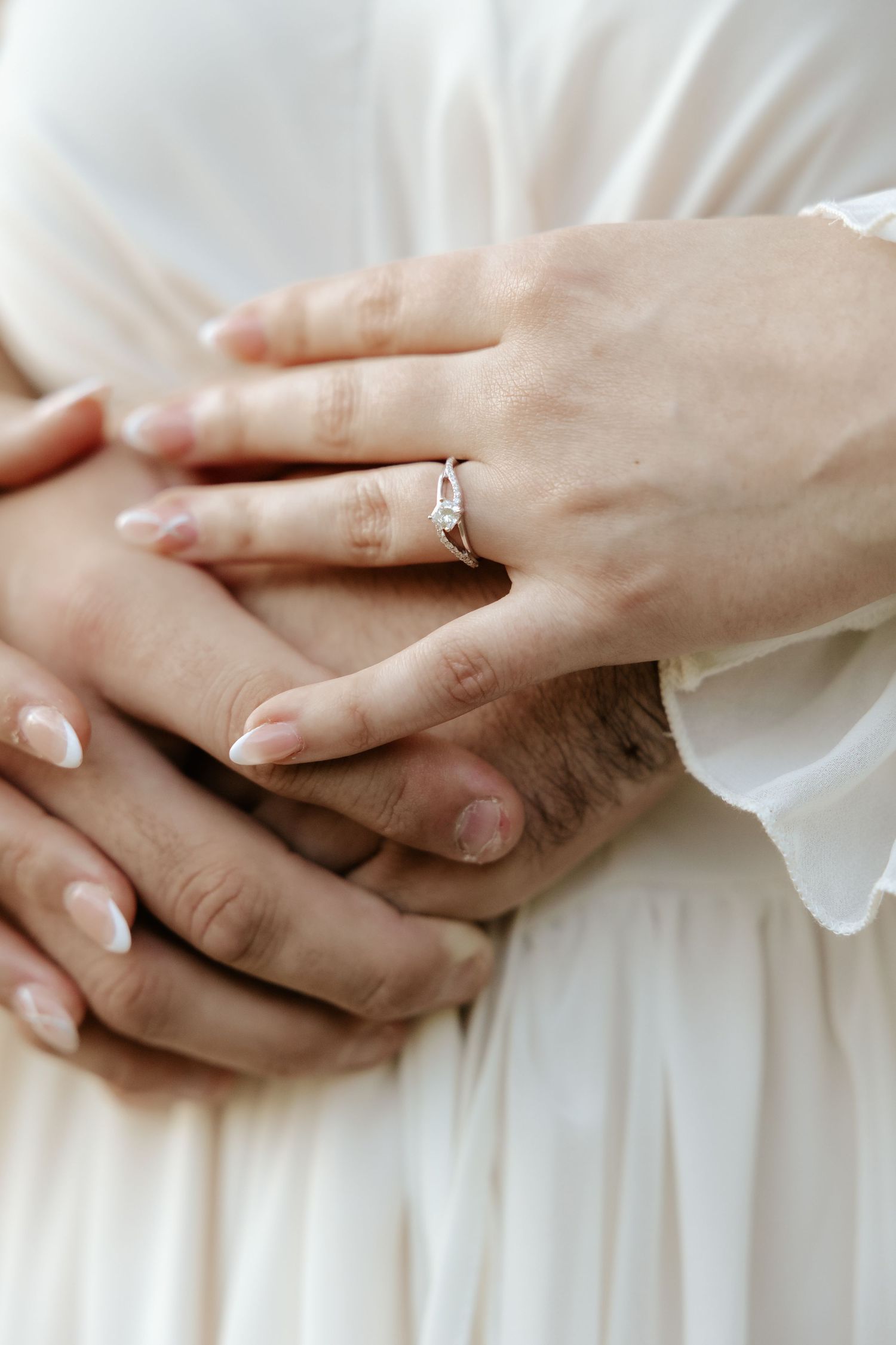 Close-up view of newly engaged couple holding hands.
