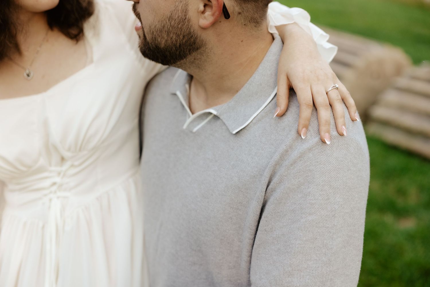 Couple shares romantic moment against stone pillars at sunset during outdoor wedding photoshoot.