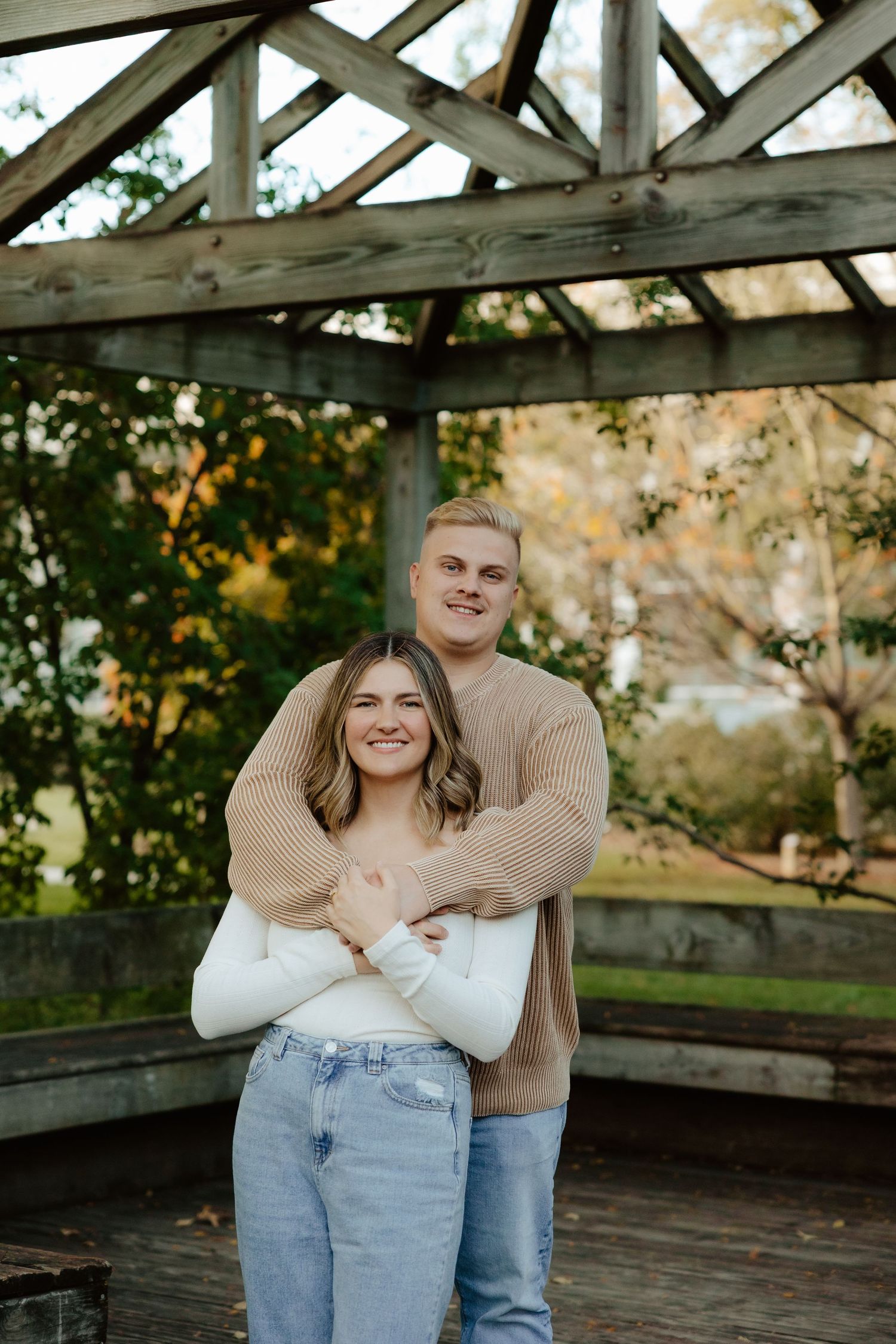 A couple embraces intimately in a rustic greenhouse setting during a romantic photoshoot at UNL east campus Lincoln NE.