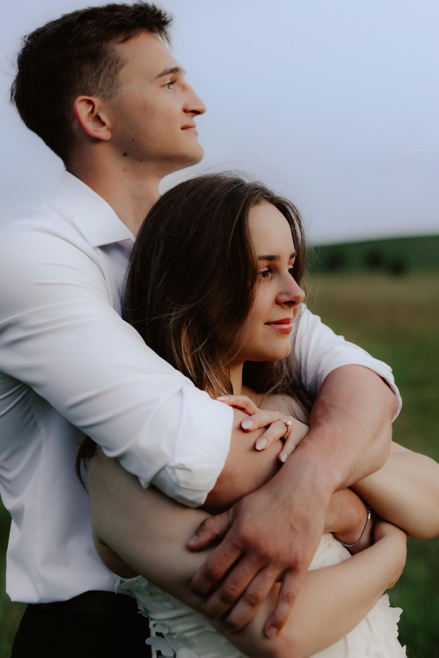 Beautiful couple sharing a romantic blue hour moment during a proposal near a serene pond at summertime in Nebraska