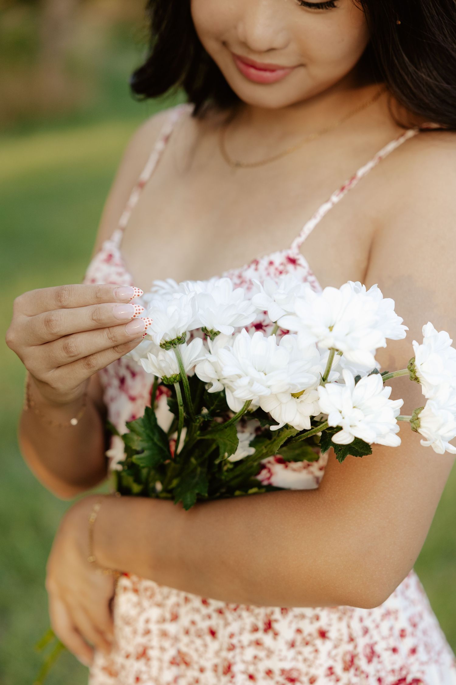 A series of closeup shots shows delicate white flowers being tenderly held against a floral patterned dress.