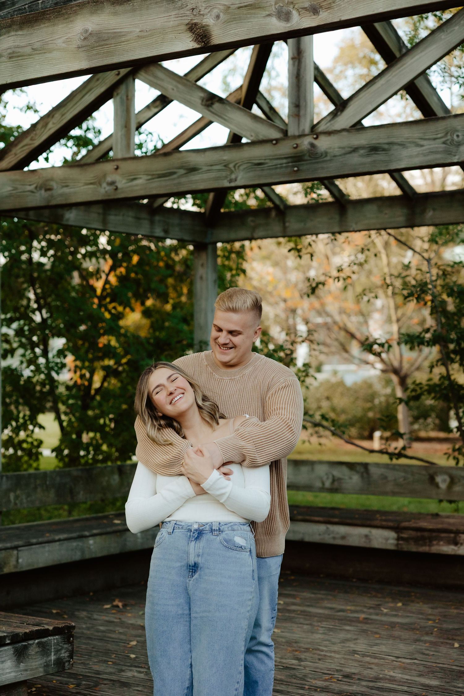 A couple embraces intimately in a rustic greenhouse setting during a romantic photoshoot at UNL east campus Lincoln NE.