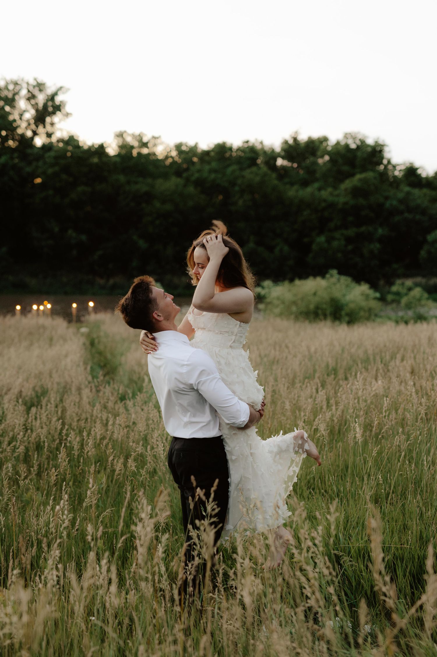 Beautiful couple sharing a romantic sunset moment during a proposal near a serene pond at summertime in Nebraska