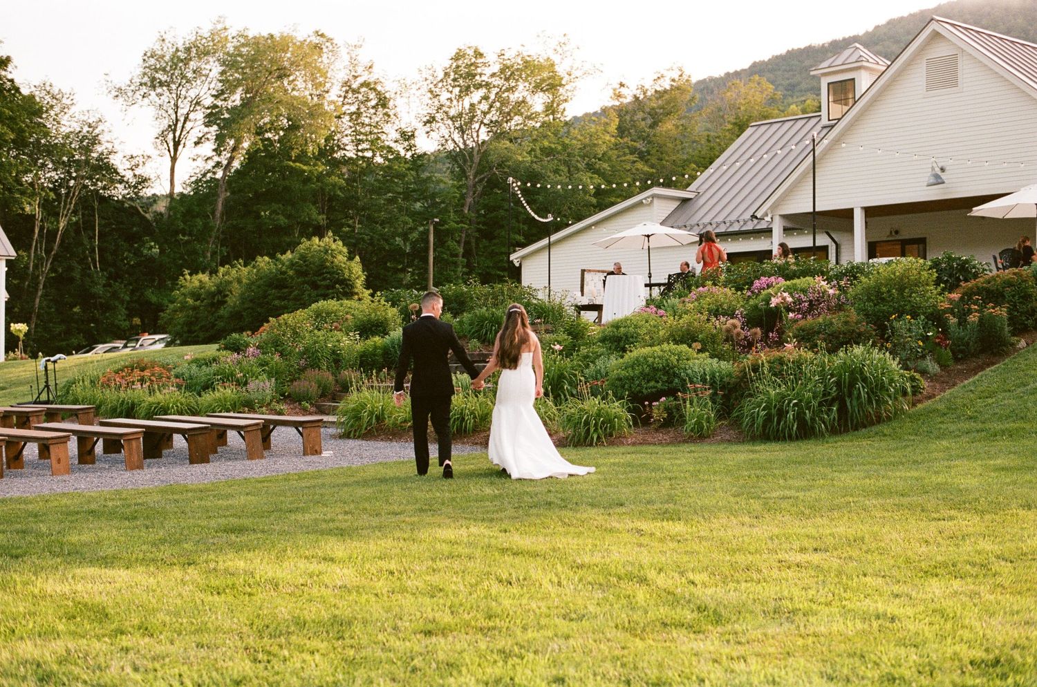 Panoramic collage of an outdoor wedding ceremony set against a lush green landscape with white decorative details.