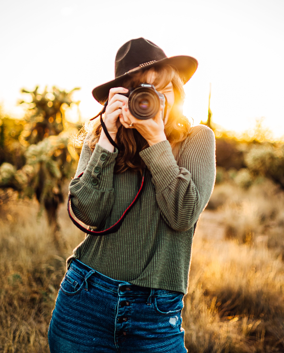 Maggie Amos of Maggie Amos Photography behind her camera shooting into the golden hour in the desert.