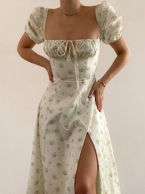 White floral midi dress with puff sleeves, square neckline, ruched bodice tie detail, and side slit.