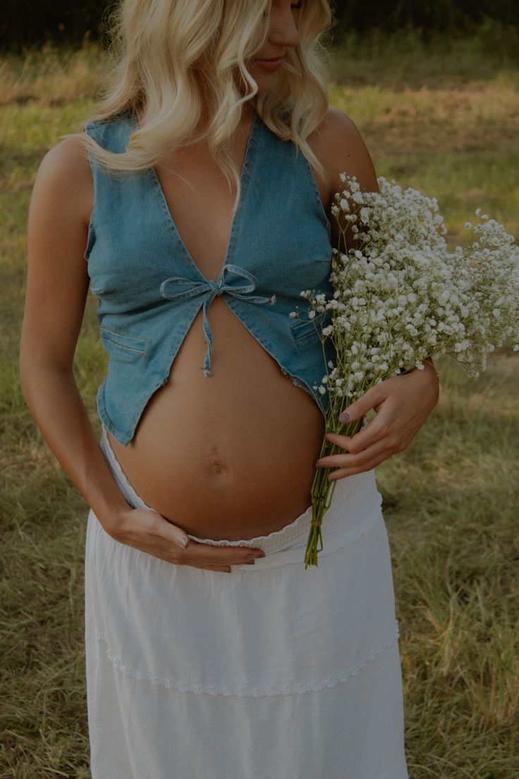 A series of pregnancy progression photos showing a growing baby bump in a teal top against a natural outdoor setting.
