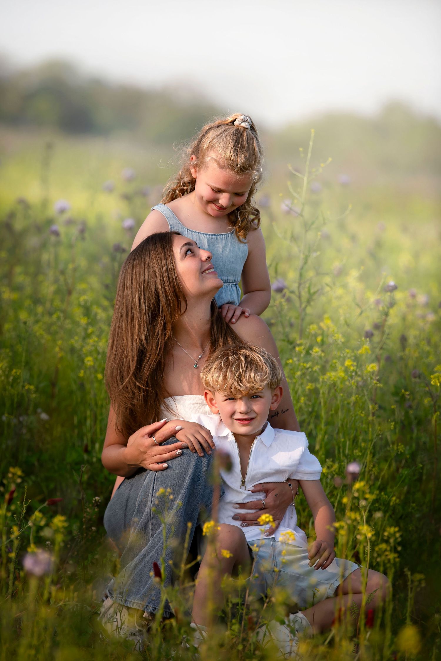 A heartwarming family portrait captured in a wild meadow filled with summer flowers.