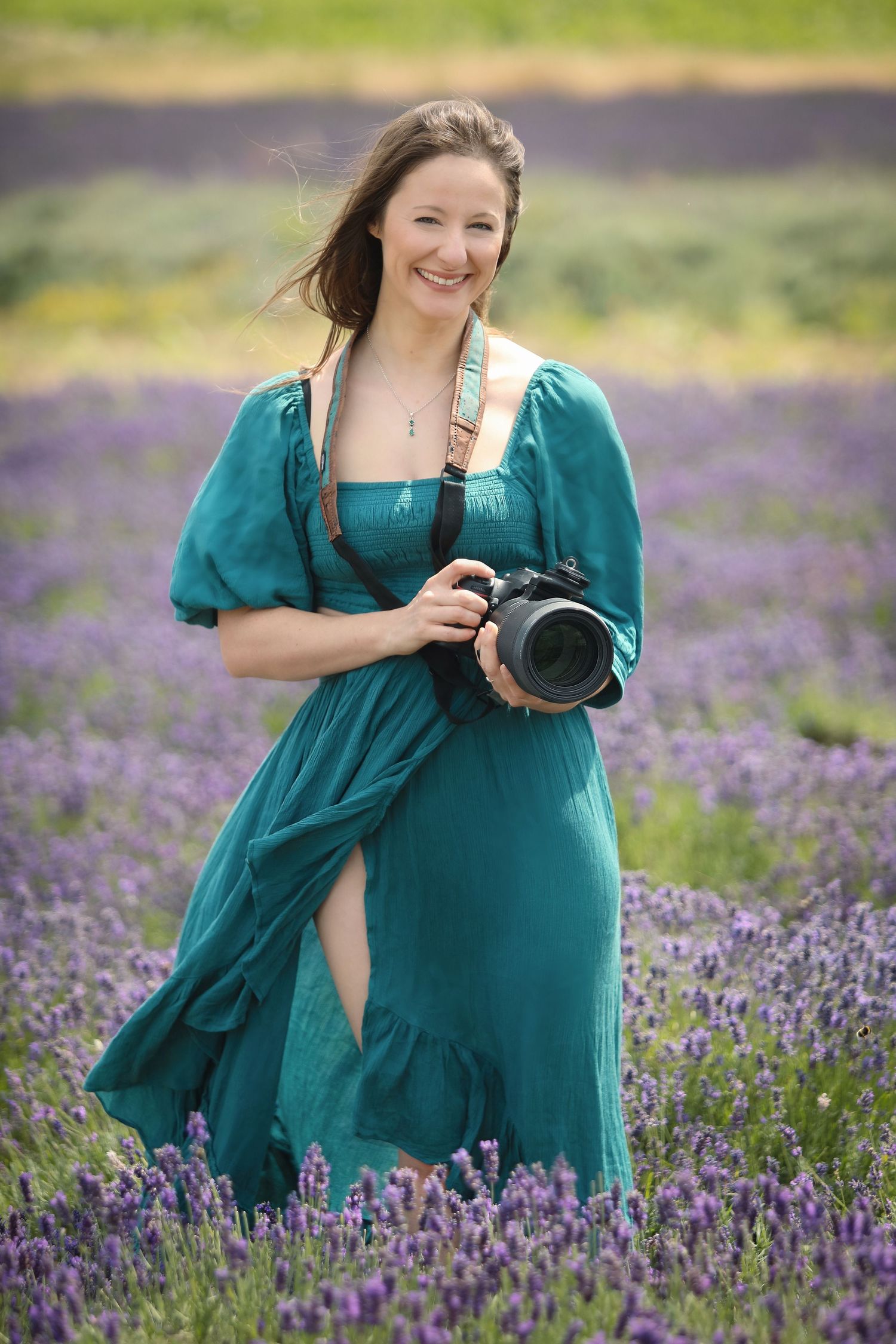Meet the Photographer standing in the blooming purple lavender field with professional camera.
