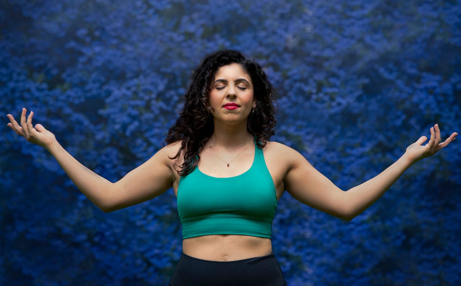 A woman practising yoga calmy poses for her branding photoshoot against a hyacinths backdrop