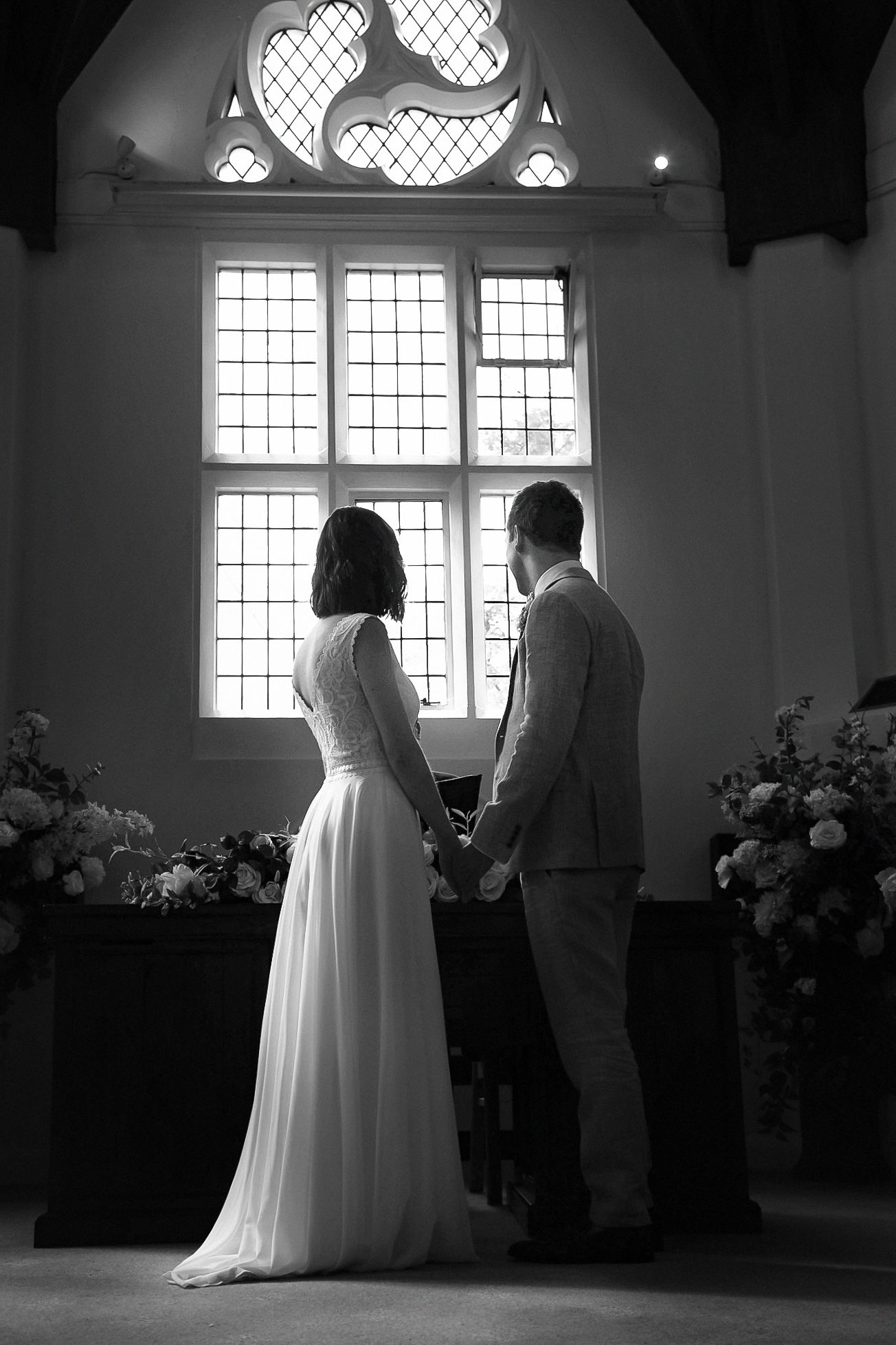 A series of black and white wedding ceremony photos showing silhouettes against bright church windows.