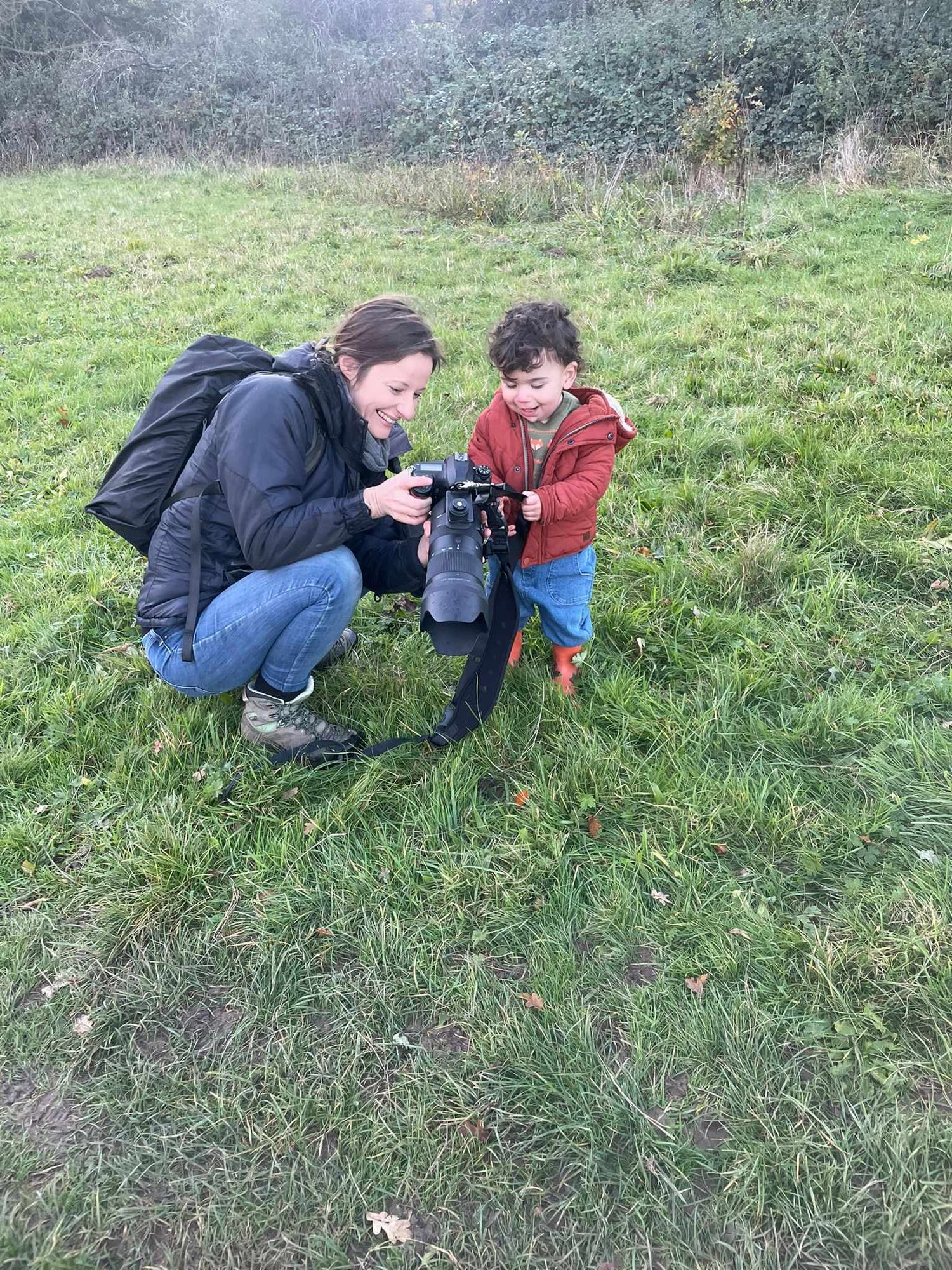 Photographer shows little boy a photo she took of him while he and his family had their portraits professionally taken.