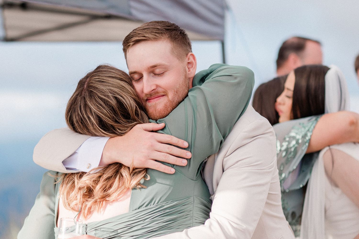 A groom hugs his mom after outdoor wedding ceremony