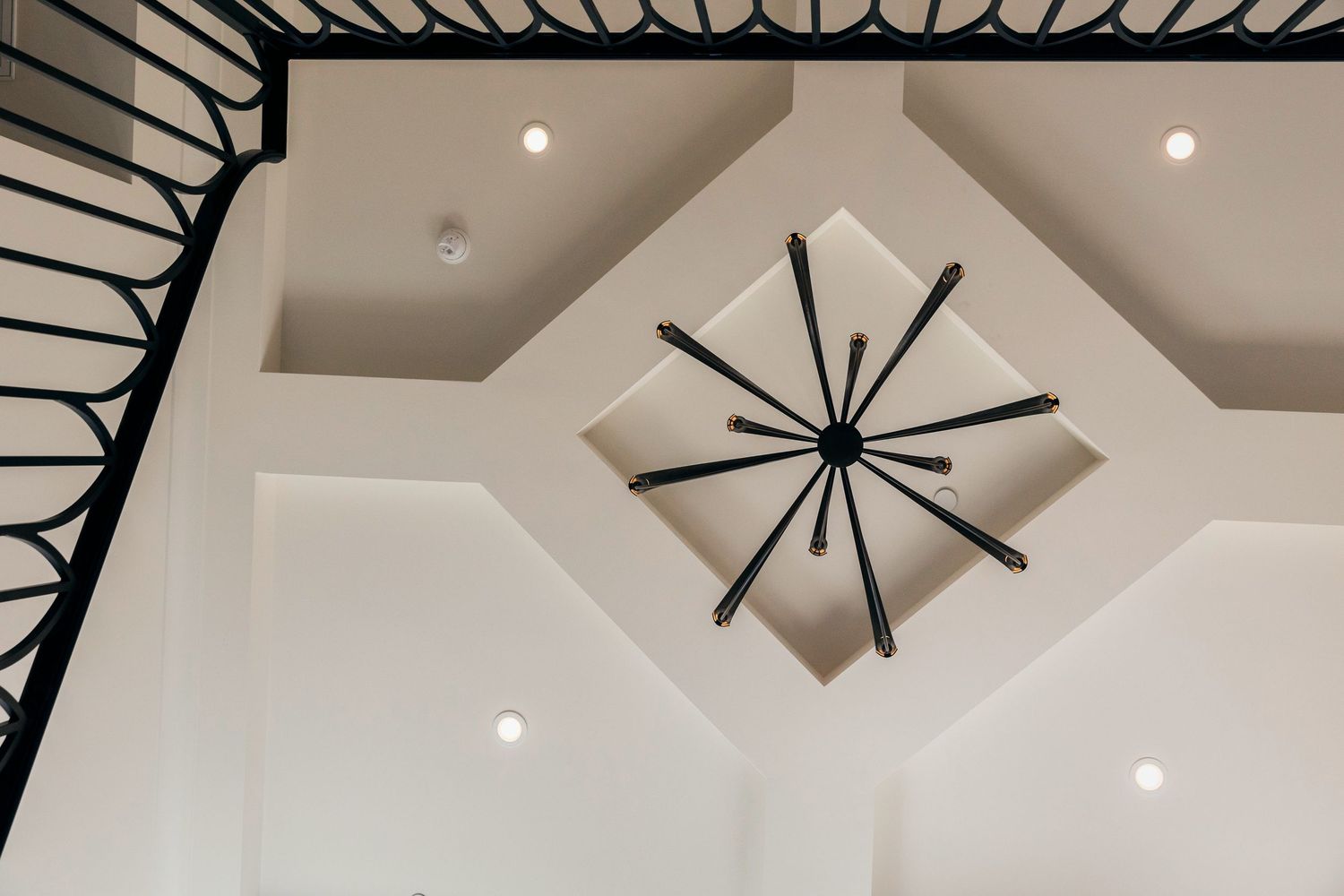 Modern home interior design featuring black ceiling fans and recessed lighting in a neutral color scheme.