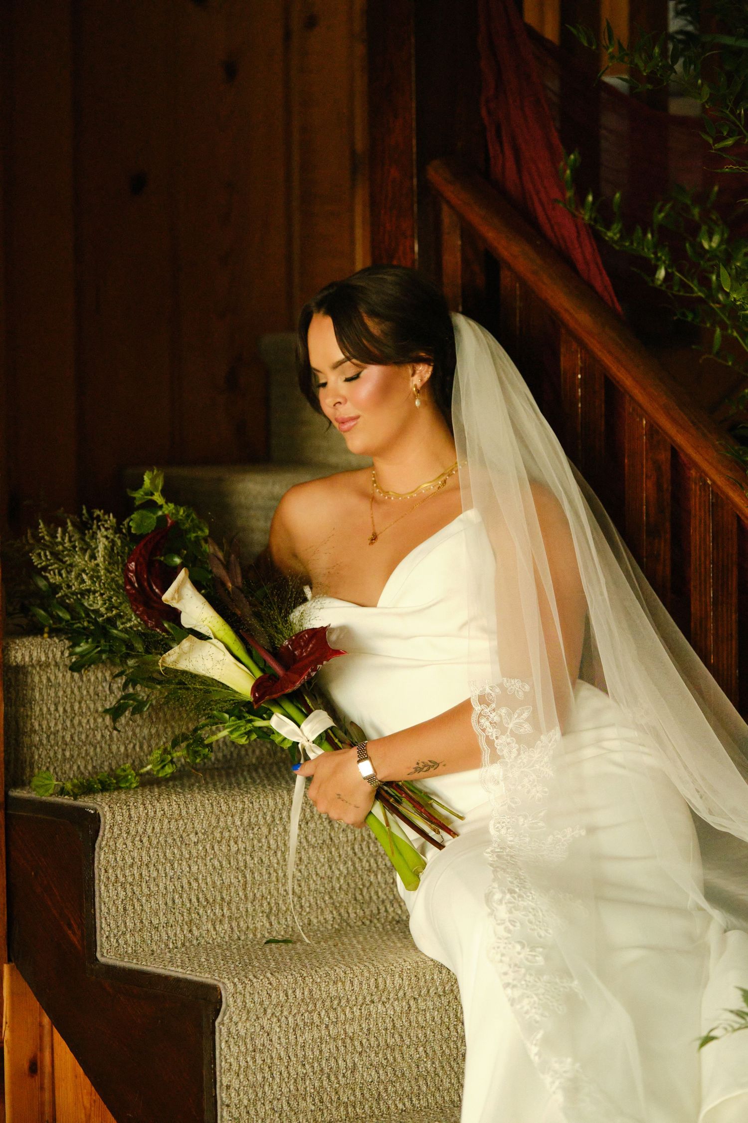 Wedding attire and bouquet details in a rustic wooden stairwell setting.
