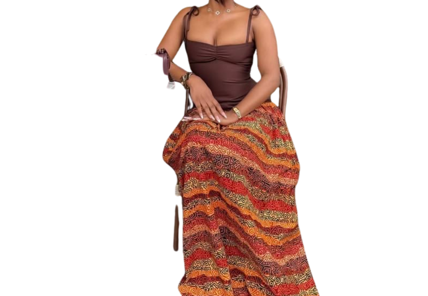 Woman in brown corset top and colorful wave-print maxi skirt seated gracefully in a chair.
