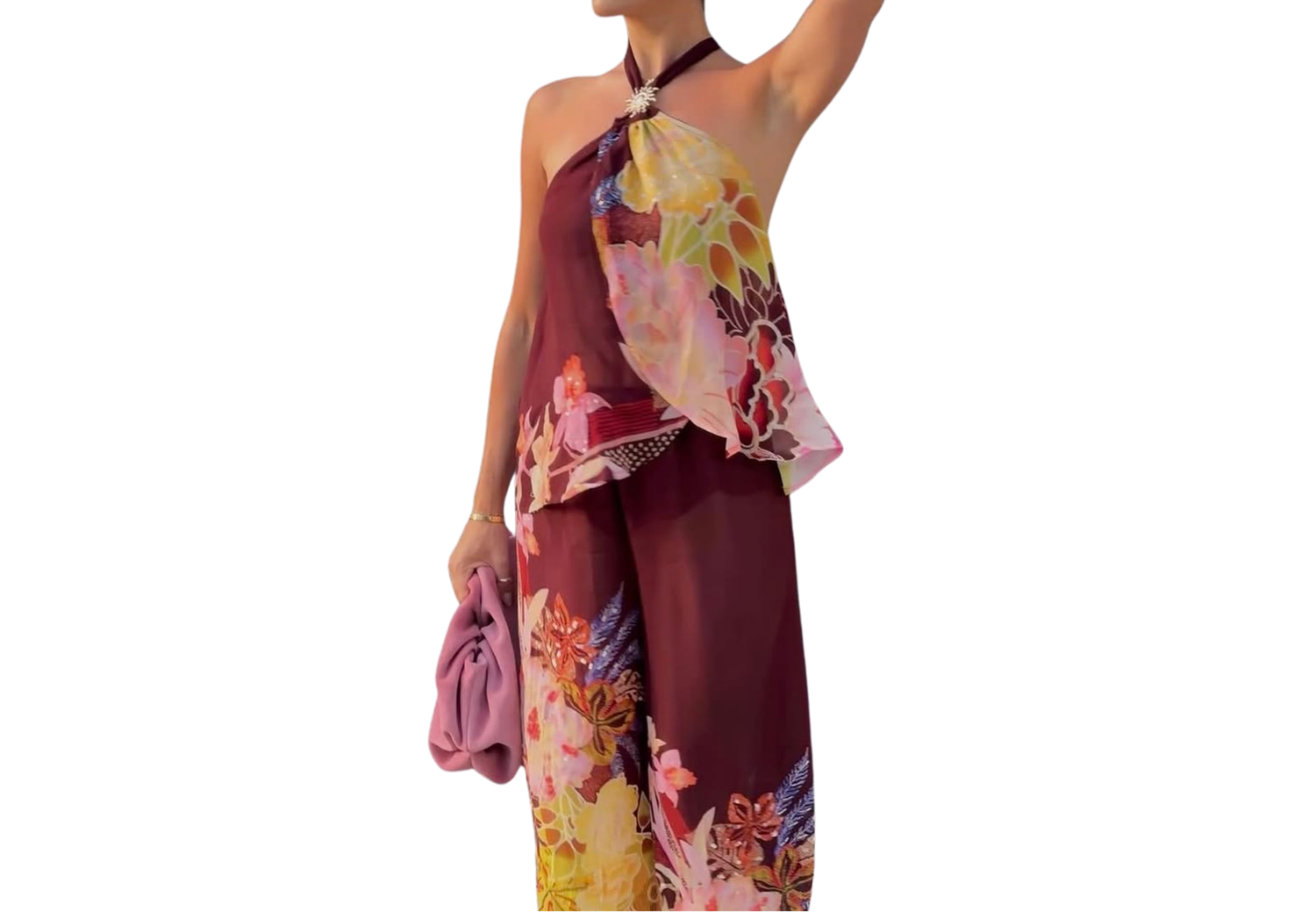 Woman wearing a floral burgundy halter top and wide-leg pants set, holding a purple bag.