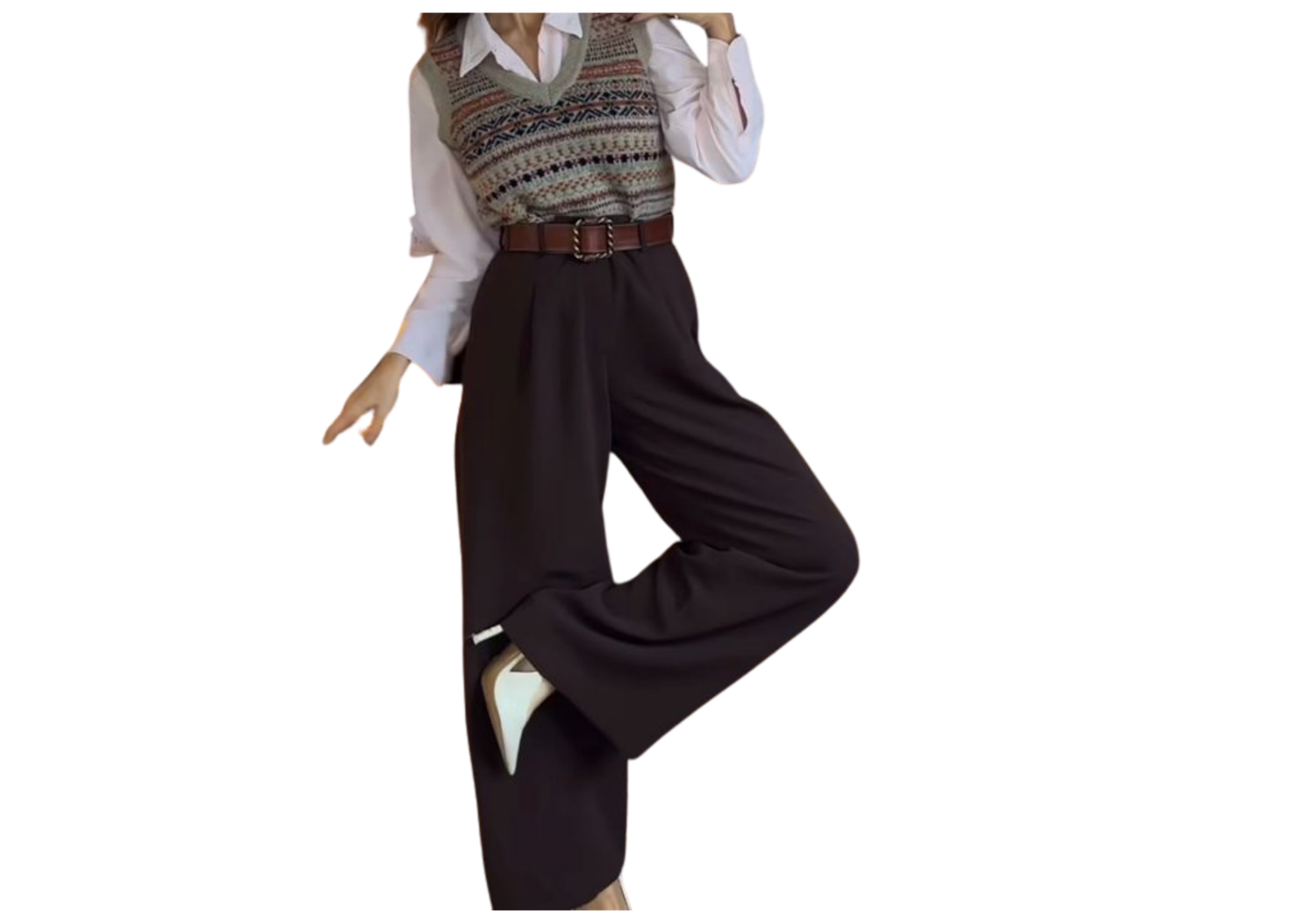 Woman wearing a patterned knit vest over white shirt with dark wide-leg trousers and white shoes.