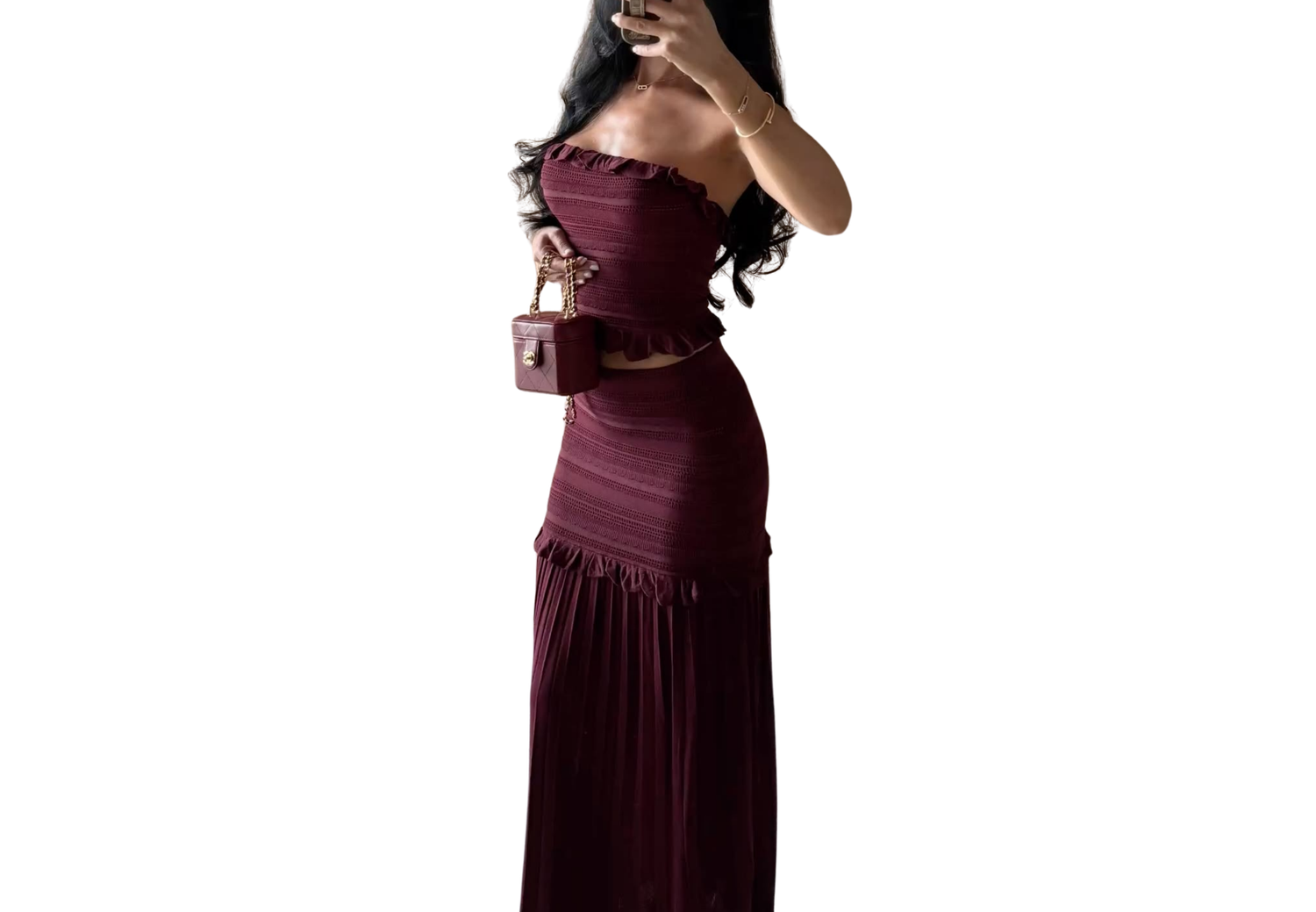 Woman wearing a burgundy ruched strapless maxi dress with matching mini bag.
