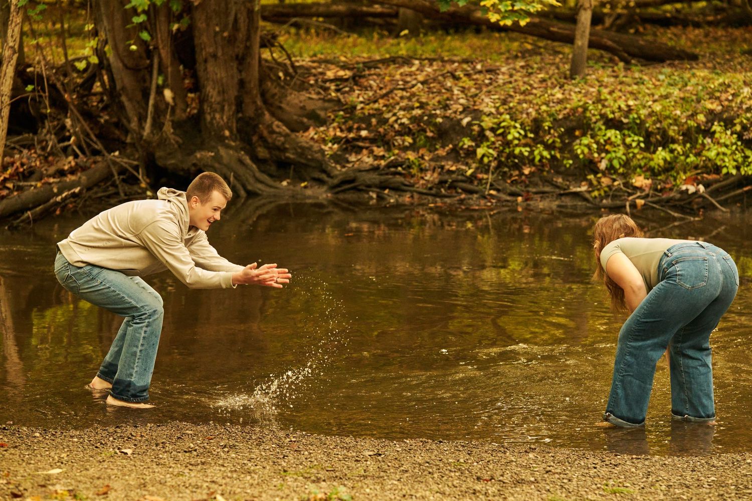 A person panning for gold in a stream using traditional equipment and methods to search for precious metals.