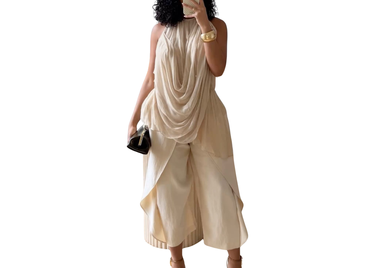 Woman wearing elegant cream halter jumpsuit with draped top and wide-leg pants, holding black clutch.