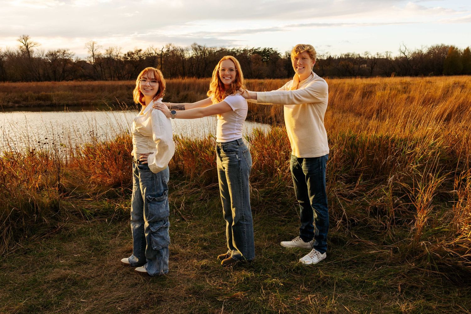 Group in matching outfits plays and poses together in an autumn field.