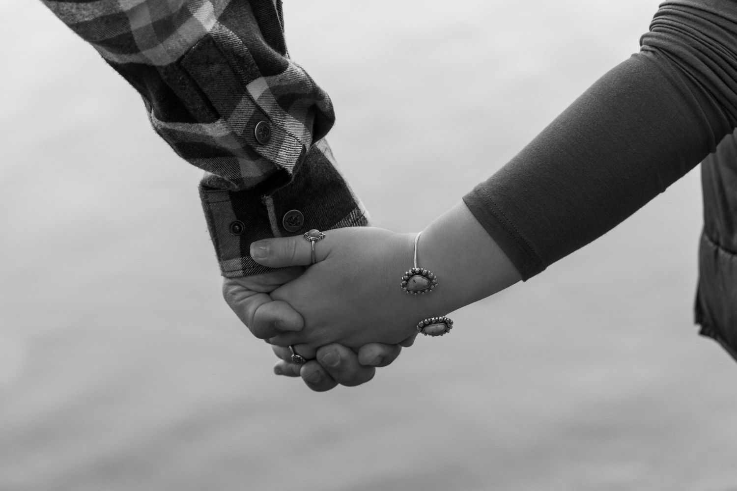 Artistic black and white photograph of hands joined together in sequence.