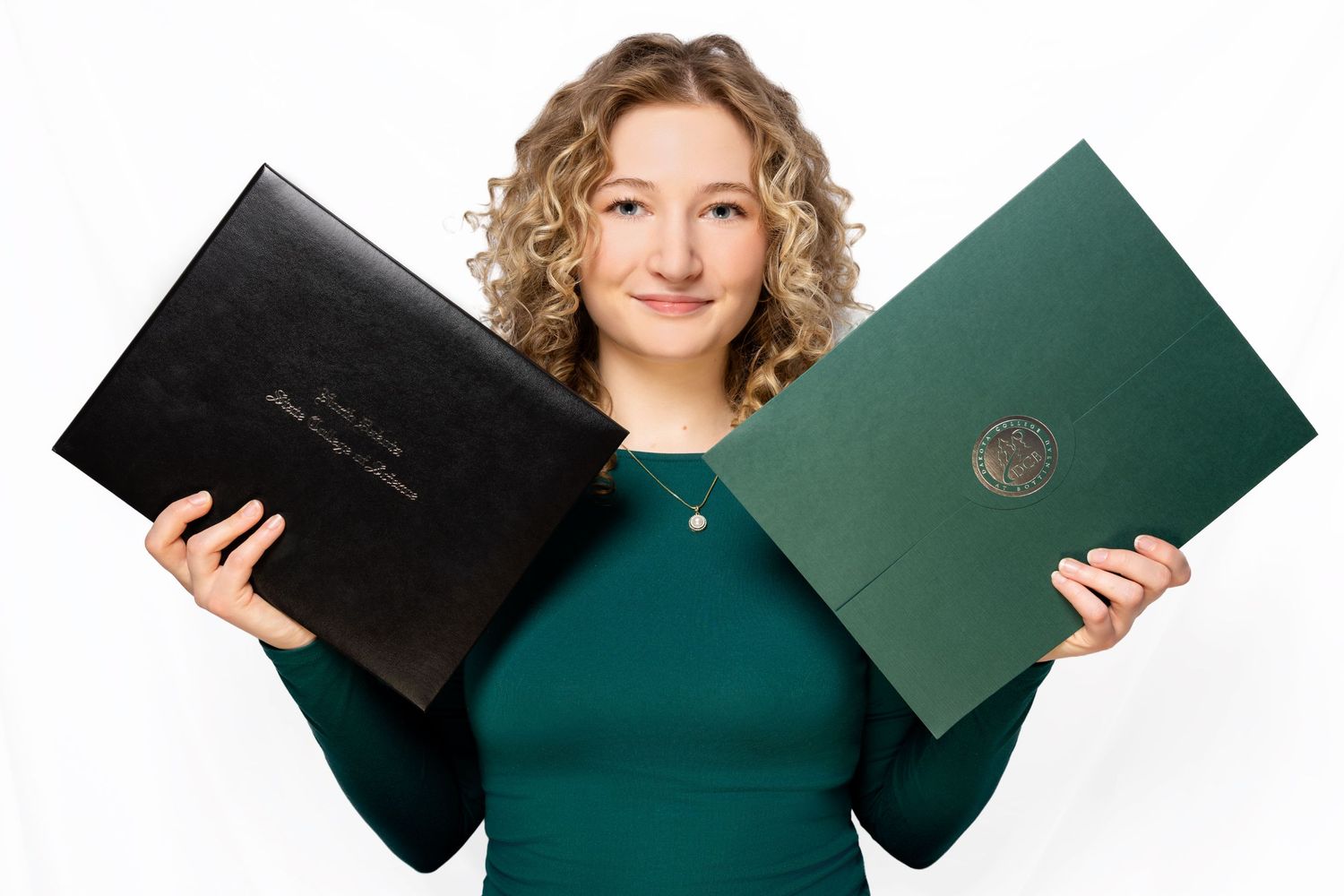 Professional holding two diploma or certificate folders in black and green against white background.