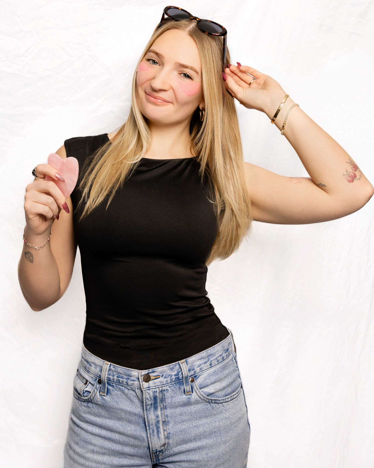 Portrait series showing playful poses in black top and jeans against white background.