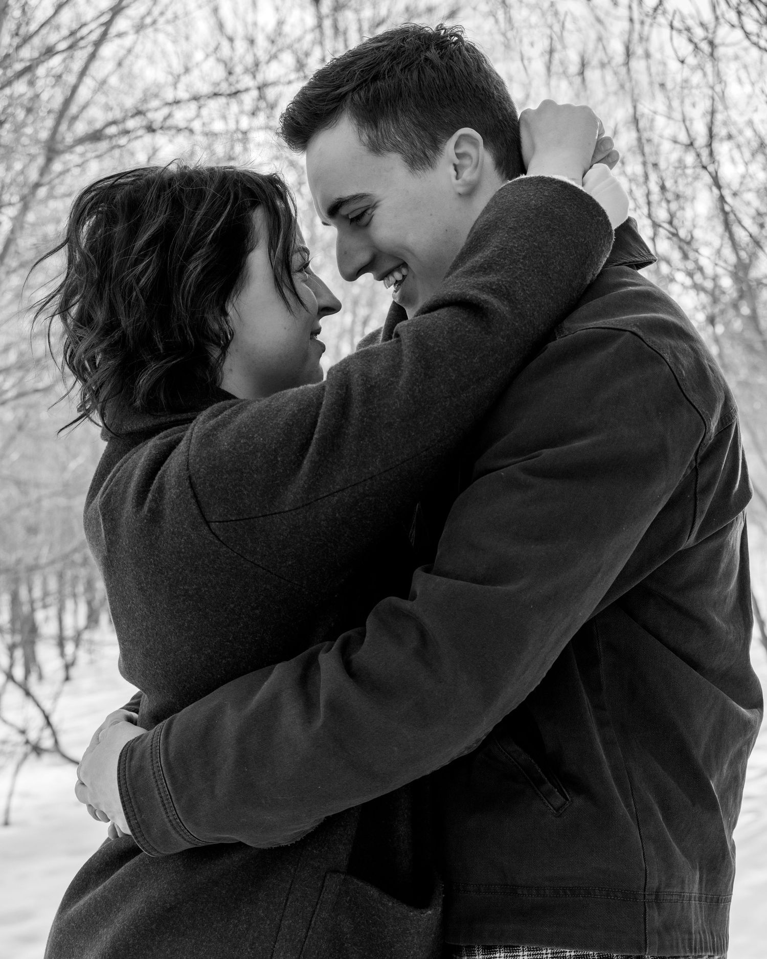 Romantic black and white photo series of a couple embracing in winter.