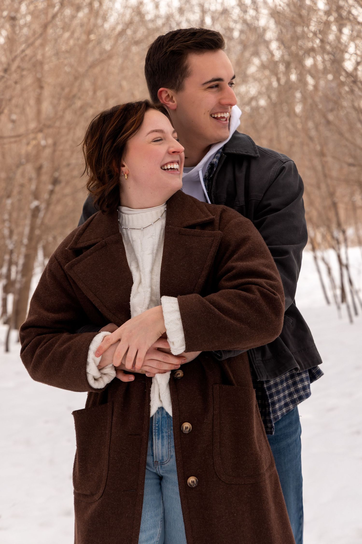 Candid moments captured in a snowy forest setting with cozy winter outfits.
