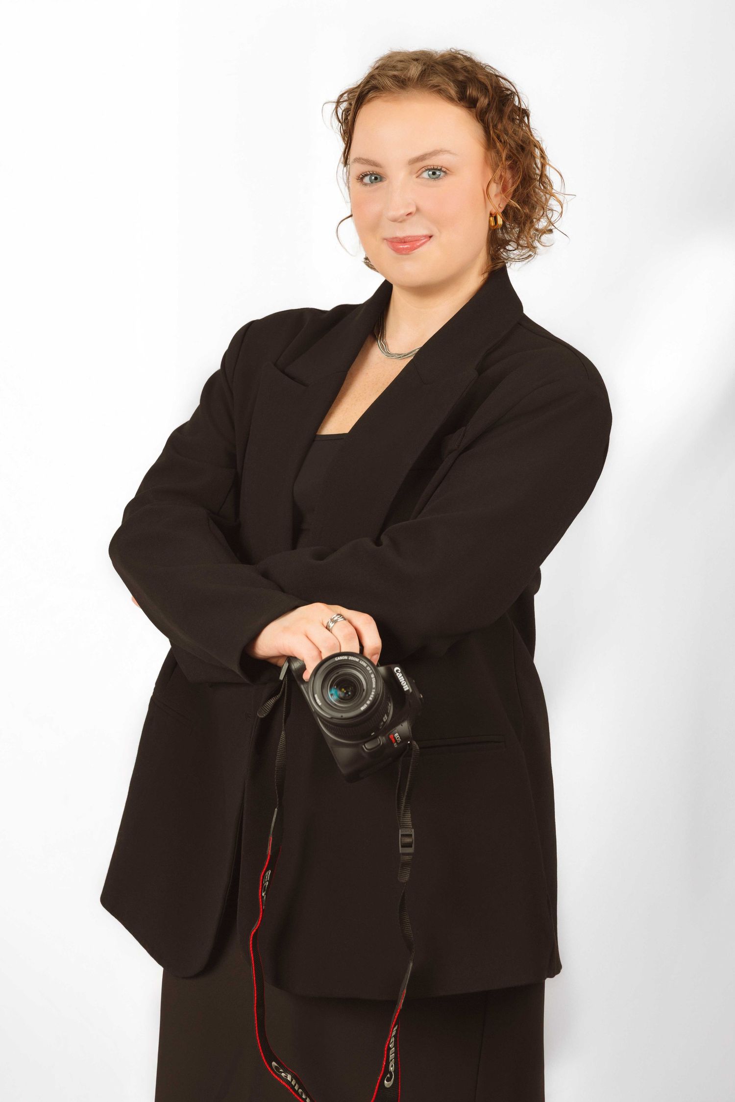 Series of poses with camera while wearing black blazer against white background.