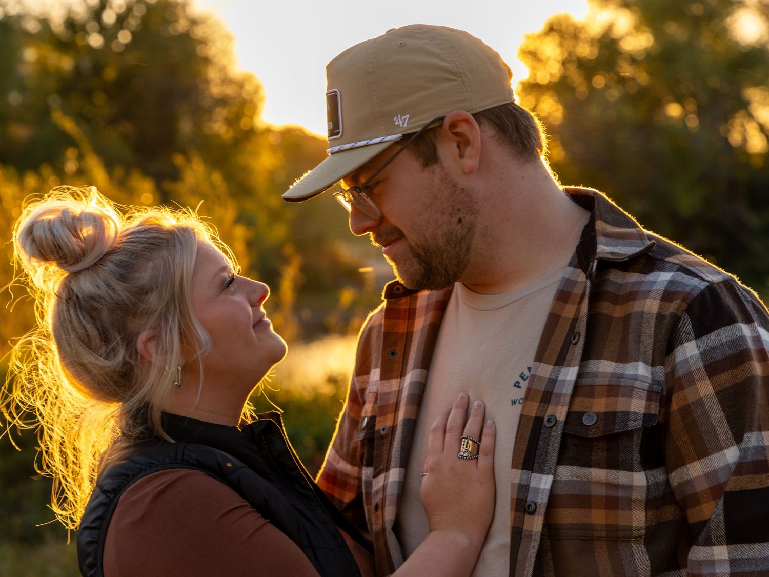 Backlit couple photography session during golden hour with natural scenery.
