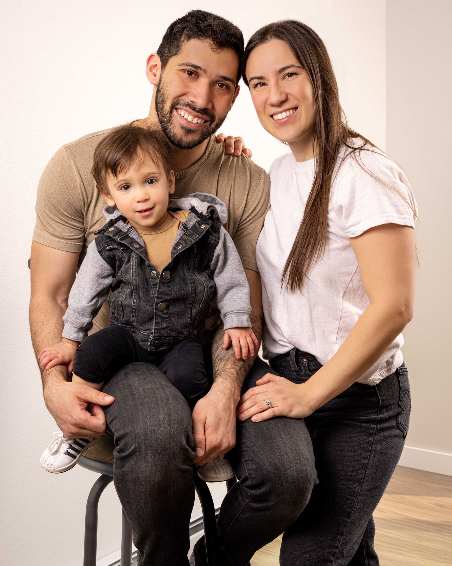 Family portrait session showing warm embraces and casual attire in a bright studio setting.