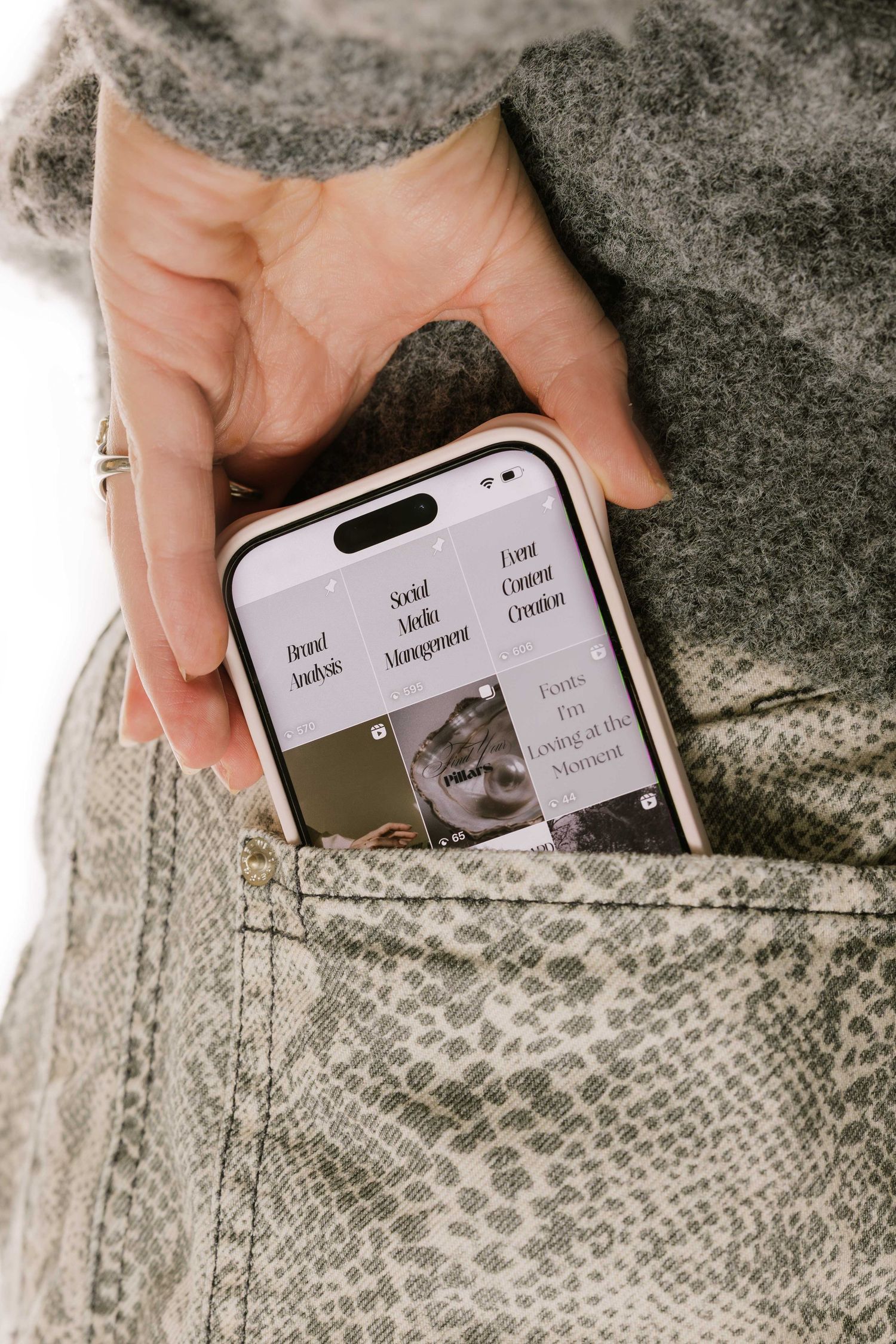 Close-up of hands holding smartphone showing website interface against textured fabric.