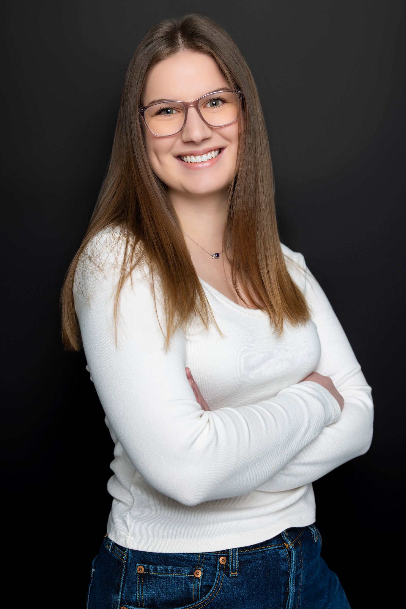 Studio portrait series against dark background showing casual white sweater and jeans outfit.