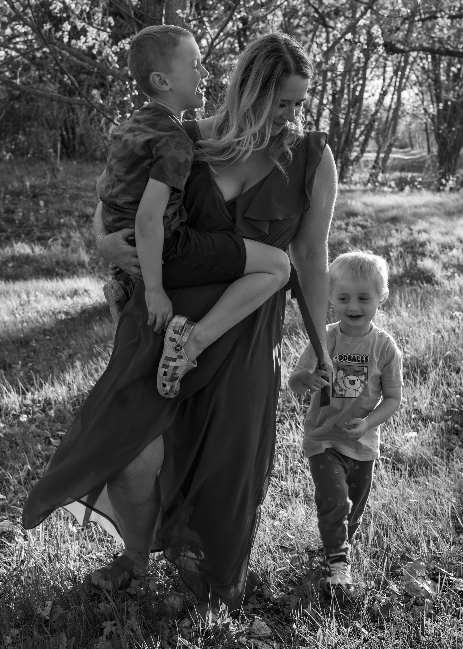 A playful outdoor photoshoot sequence in black and white showing joyful interaction in a grassy field.