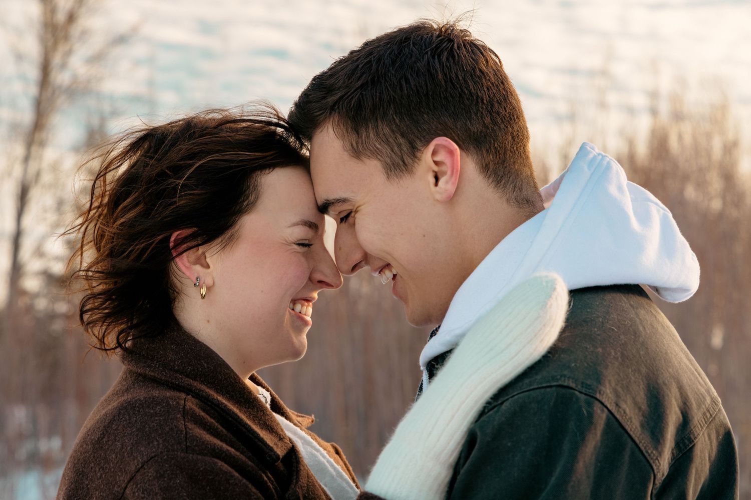 Intimate couple moment captured at sunset with warm lighting.