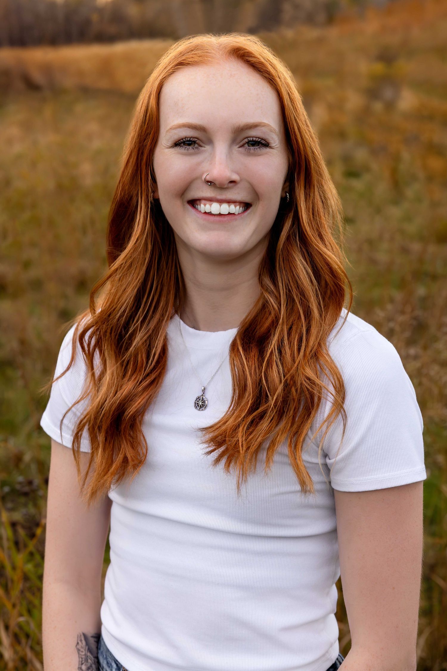 Portrait series in autumn setting showing bright expressions against natural background.