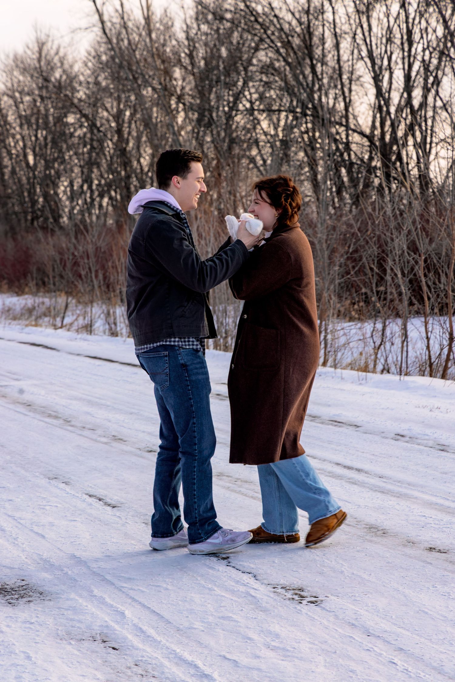 Playful winter photoshoot in the snow with couples in casual winter clothing.