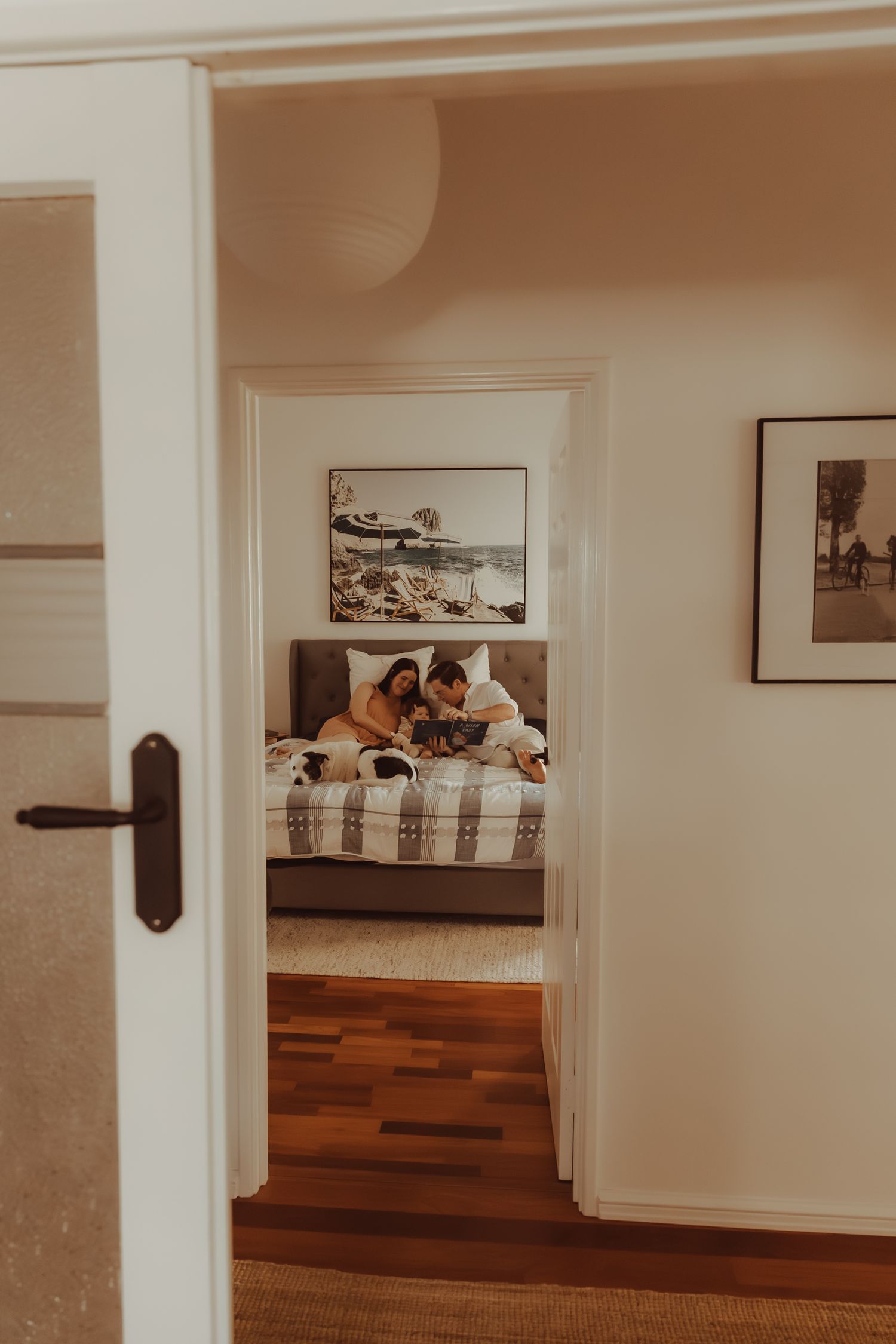 A series of five connected gallery wall photos showing framed artwork in a minimalist white interior space.