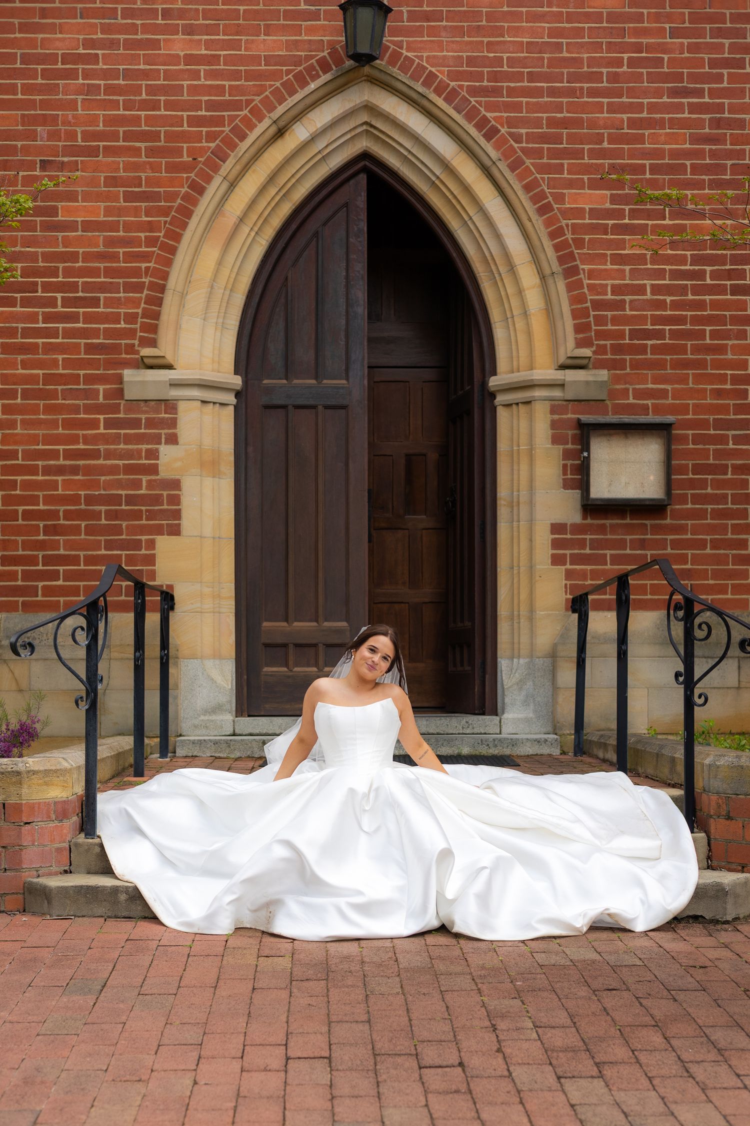 A sequence of four photos showing a person in a white wedding dress laying down in front of a brick church entrance.