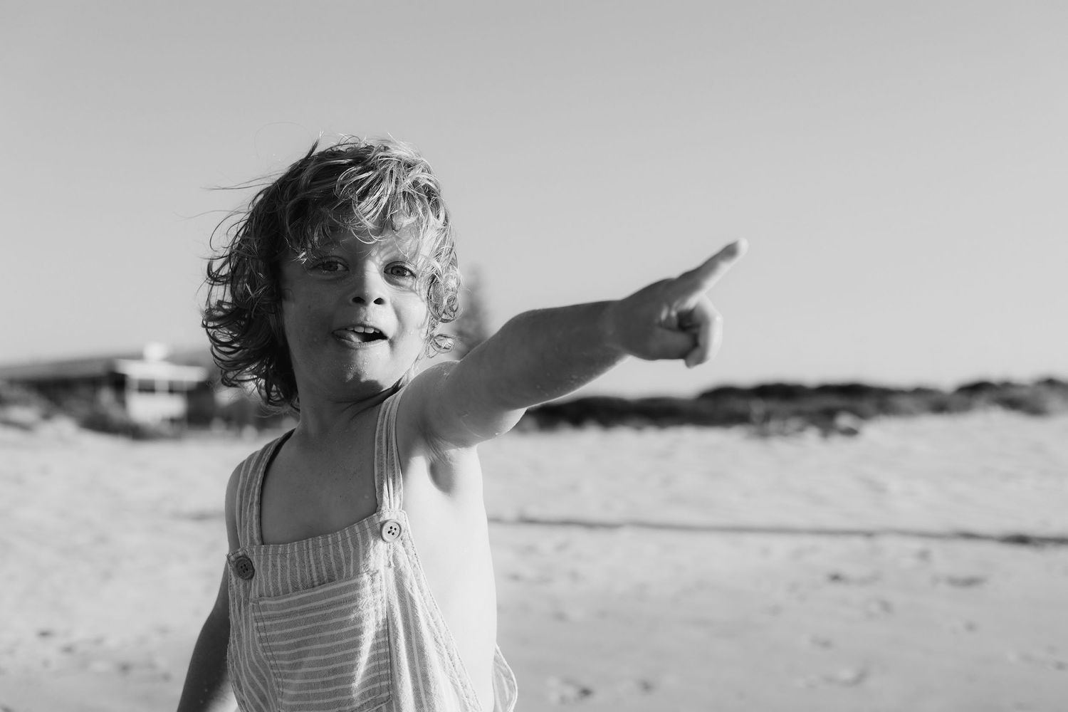 Black and white candid shots of a child playing on a sandy beach. Family Photography Fremantle Perth