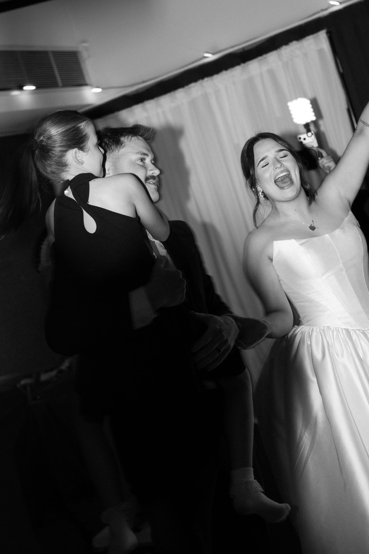 A candid black and white photo of joyful celebration at a wedding reception. Perth wedding documentary photography, elopement